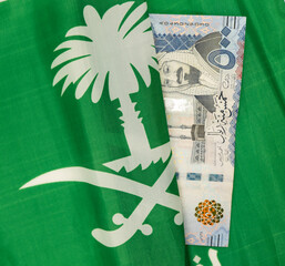 500 Saudi Riyal Bank note with flag of Saudi Arabia in background