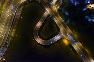 Aerial view of freeway interchange offramp and bridge over canal with traffic from top down high angle