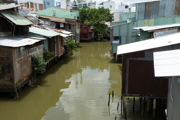 Fototapeta na wymiar row of Houses made from corrugated iron and on stilts along a narrow canal in Ho Chi Minh City, Vietnam