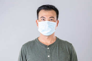 Thai man wearing protective face mask to prevent virus studio shot on grey background
