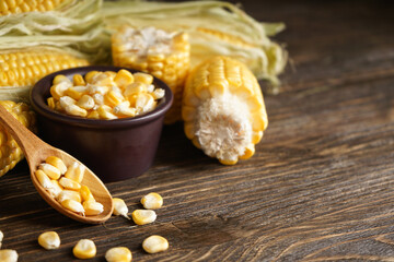 Fresh corn on the cob of corn on a wooden background, place for text.