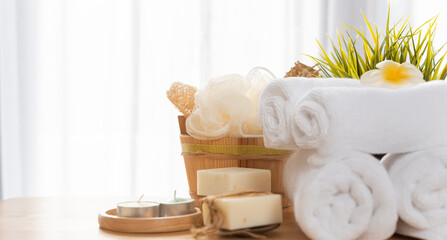 Bath and spa set of naturel products for body care and bath accessories  with soap,scrub,candle,oil,comb, and white towels in white room interior