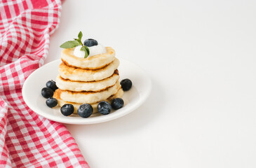 Closeup of pancakes with fresh blueberries on white background.