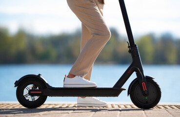 Obraz premium Woman standing on electric scooter