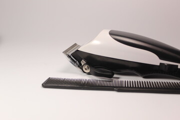 Hair trimmer and a comb on white background 