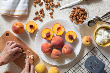 Grilled peaches summer dessert American bbq. Served with almonds, ice cream and cookie crumbs. top view