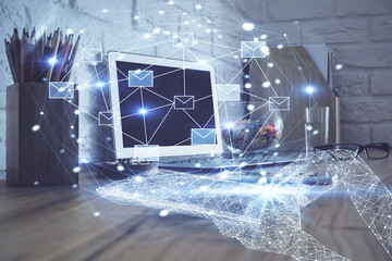 Desktop computer background in office and flying envelops hologram drawing. Double exposure. Electronic mail concept.