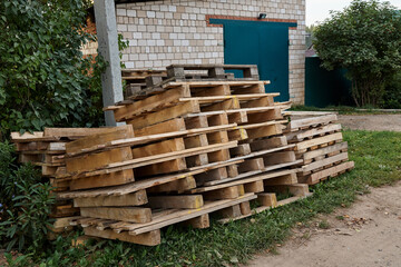 A stack of wooden pallets lying on the grass in the countryside.