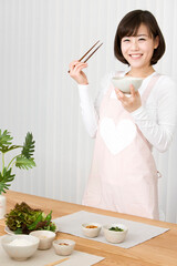 young woman setting table with rice and vegetable