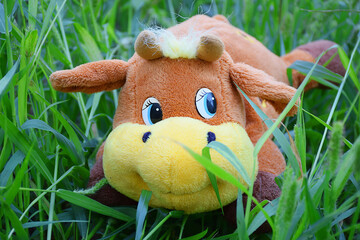 Toy cow in the grass in the garden