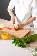 young woman cooking in kitchen with vegetable
