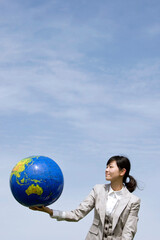 young businesswoman holding a globe in the air