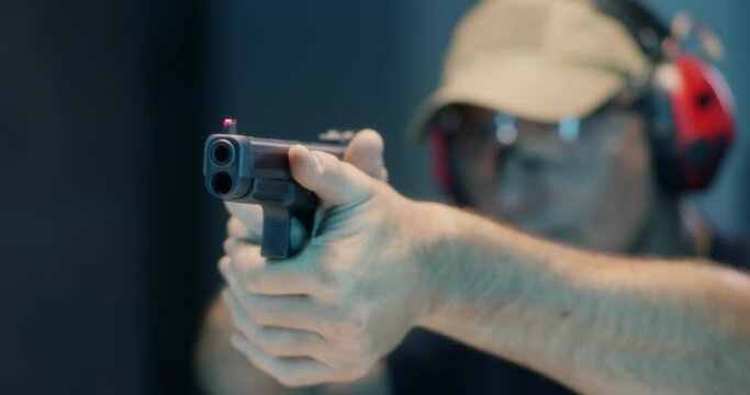 Middle aged shooter firing pistol