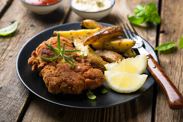 Homemade breaded German Weiner schnitzel with potatoes and lemon