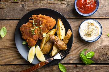 Homemade breaded German Weiner schnitzel with potatoes and lemon