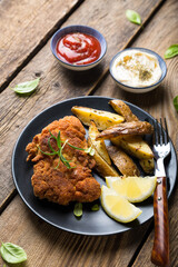 Homemade breaded German Weiner schnitzel with potatoes and lemon