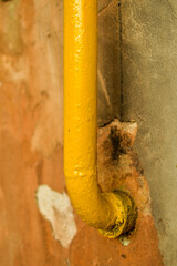 yellow gas pipe leaving a ragged wall