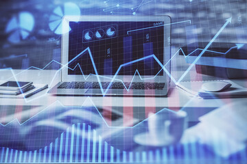 Financial graph colorful drawing and table with computer on background. Multi exposure. Concept of international markets.