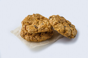 Homemade oatmeal cookies with raisins and chocolate on white background. Healthy snack before bedtime or nutritious breakfast. Fresh baked wholegrain cookies