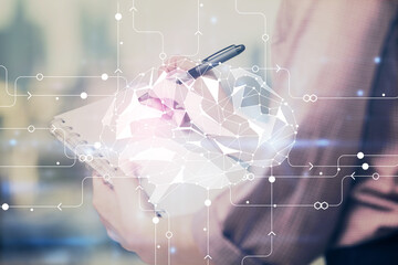 Multi exposure of woman's writing hand on background with brain hologram. Concept of brainstorming.