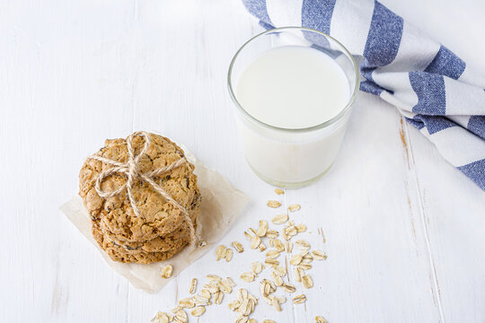 Homemade Oatmeal Cookies With Raisins And Chocolate And Glass Of  Milk On White Table. Healthy Snack For Kids Before Bedtime Or Nutritious Breakfast. Fresh Baked Wholegrain Cookies