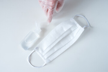 Coronavirus protection concept with medical mask, thermometer, hand sanitizer and gloved hand in the white background. Wuhan second wave lockdown. Covid-19 coronavirus pandemic. Copy space