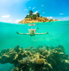 Split view of female apnea underwater and paradisiacal landscape of coral reef island. Snorkeling woman exploring sealife of Indian Ocean, under and above water photography.