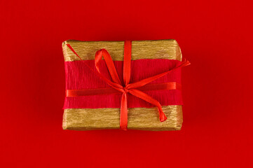 Gold gift box with red ribbon.