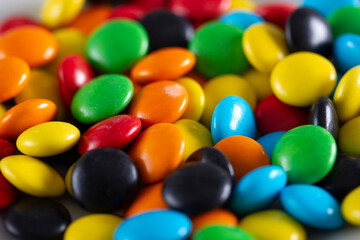 Rainbow-colored candies, multicolored close-up, texture, background.