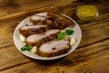 Baked pork belly in a plate on wooden table
