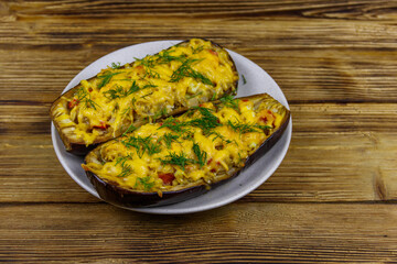 Baked stuffed eggplants on a wooden table. Healthy food and dieting concept