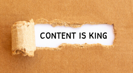Text Content is King appearing behind torn brown paper