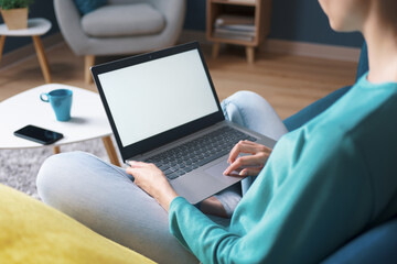 Woman relaxing at home and connecting with her laptop