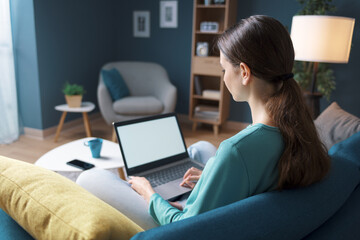 Woman resting on the sofa and connecting with her laptop