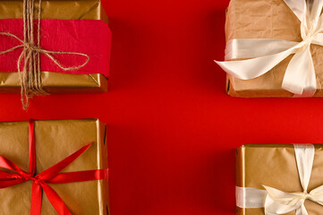 Different christmas gift boxes on red background, top view.