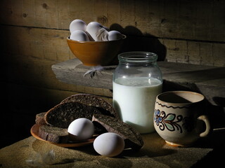 Chicken eggs and milk in the barn, village. Still life.
