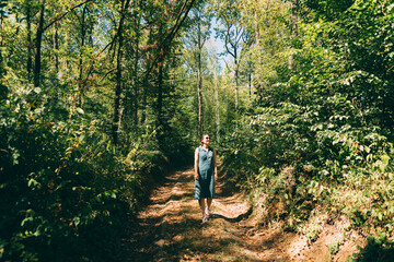 Photo of young beautiful woman walking in forest and relaxing