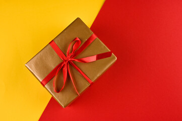 Christmas gift box against yellow-red background. Holiday greeting card. 