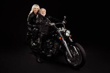 Naklejka na ściany i meble Portrait of his he her she nice attractive cool free content cheerful cheery trendy grey-haired rockers driving chopper world travelers hobby isolated over black color background