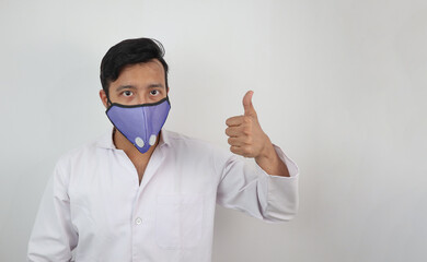 a medical professional in white coat and n 99 mask with thumbs up positive expression isolated in white background with space for text