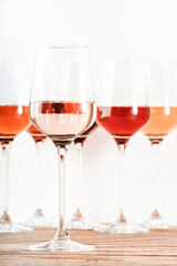 Rose wine glasses set on wine tasting. Tasting different varieties, colors and shades of pink wine concept. White background