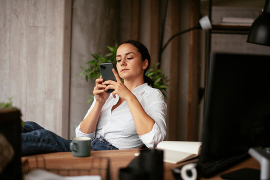 Beautiful businesswoman working in the office. Young woman using the phone.