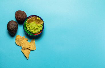 Aguacate, guacamole and nachos over a blue surface