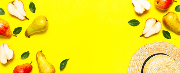 Ripe fresh green red pears, straw hat on yellow background flat lay top view copy space. Fruit background, organic healthy food. Harvest concept. Creative background with pears and green leaves