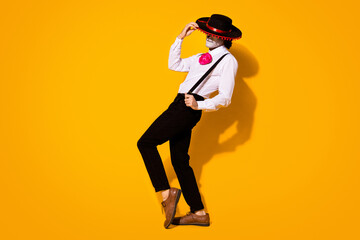 Full length photo of scary dangerous enigmatic guy charismatic charming dance hold cap wear white shirt rose death costume sugar skull sombrero suspenders isolated yellow color background