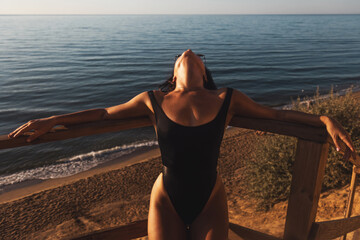 Fototapeta na wymiar gorgeous girl relaxes on a cliff over the ocean