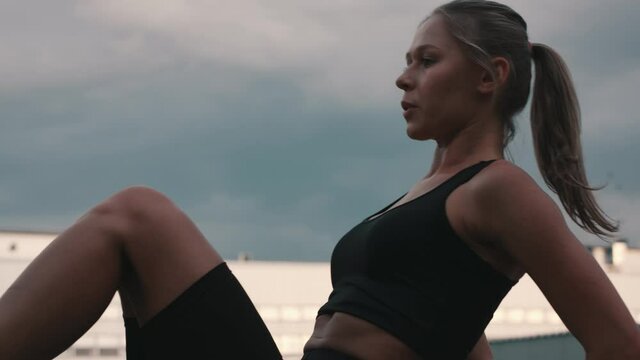 Close up of Athletic Young Woman in Black Sportswear Doing Crunch Exercise as part of Intensive Abs and Cardio Fitness Workout. Sporty Girl Training Outdoors for Keeping Fit.
