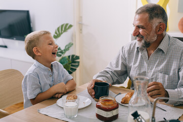 grandfather and grandson having breakfast at home