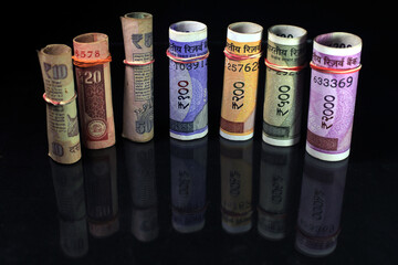 Now and old Indian currencies. 50, 100, 200, 500 rupee notes and coins. Indian currency isolated on black background.