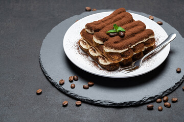 Classic tiramisu dessert on ceramic plate on concrete background